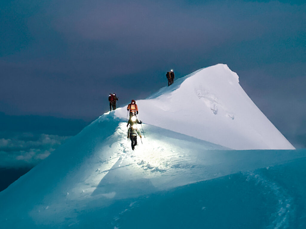 The LHO team approaching the summit of Mont Blanc at sunrise, coming over the top of the first mogul on their Mont Blanc climb.