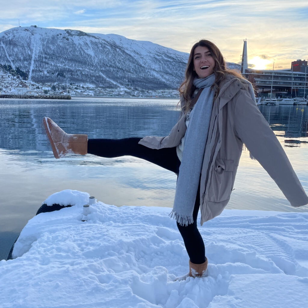 LHO Co-founder and Team Leader Ghida Arnaout kicking up the snow in Tromsø against the backdrop of the beautiful fjords during the Chase the Northern Lights adventure with the Life Happens Outdoors team.