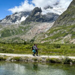 Ghida Arnaout, LHO Team Leader and co-founder, walks with an LHOer beside alpine lakes in Val Veny on the Italian side of the Tour du Mont Blanc, with the south face of Mont Blanc rising in the background.