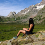 Life Happens Outdoors trekker sitting at the entrance of Val Veny on the Tour du Mont Blanc trail, reflecting after completing the hardest climb toward Col de la Seigne.