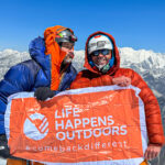 Rami Rasamny and LHO mountaineer Tony Aoun on the summit of Ama Dablam holding the Life Happens Outdoors flag, symbolizing adventure travel and transformation.