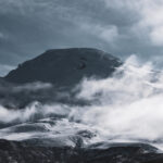 Mount Chimborazo emerging through the clouds at sunrise as seen from Whymper Refuge during a Life Happens Outdoors climbing expedition in Ecuador.