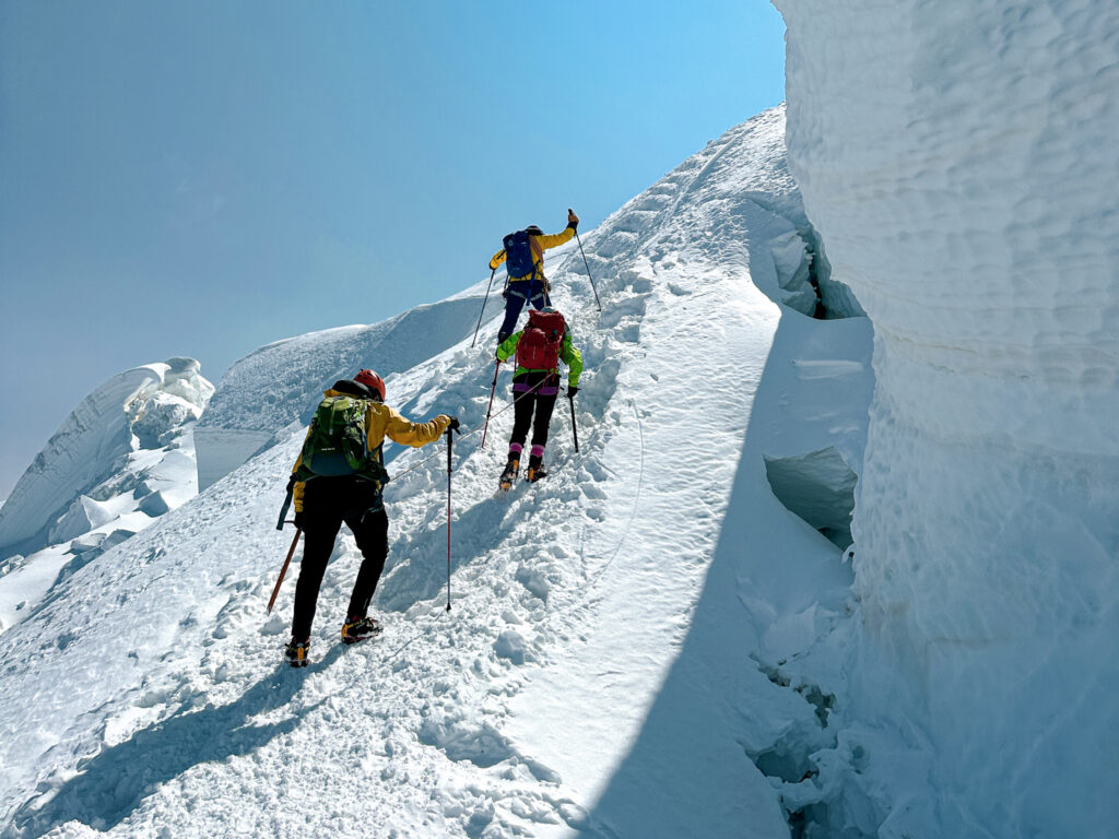 LHO mountaineers tackling the steep moguls below the Mont Blanc summit beneath towering seracs on their alpine ascent from the Gouter Hut