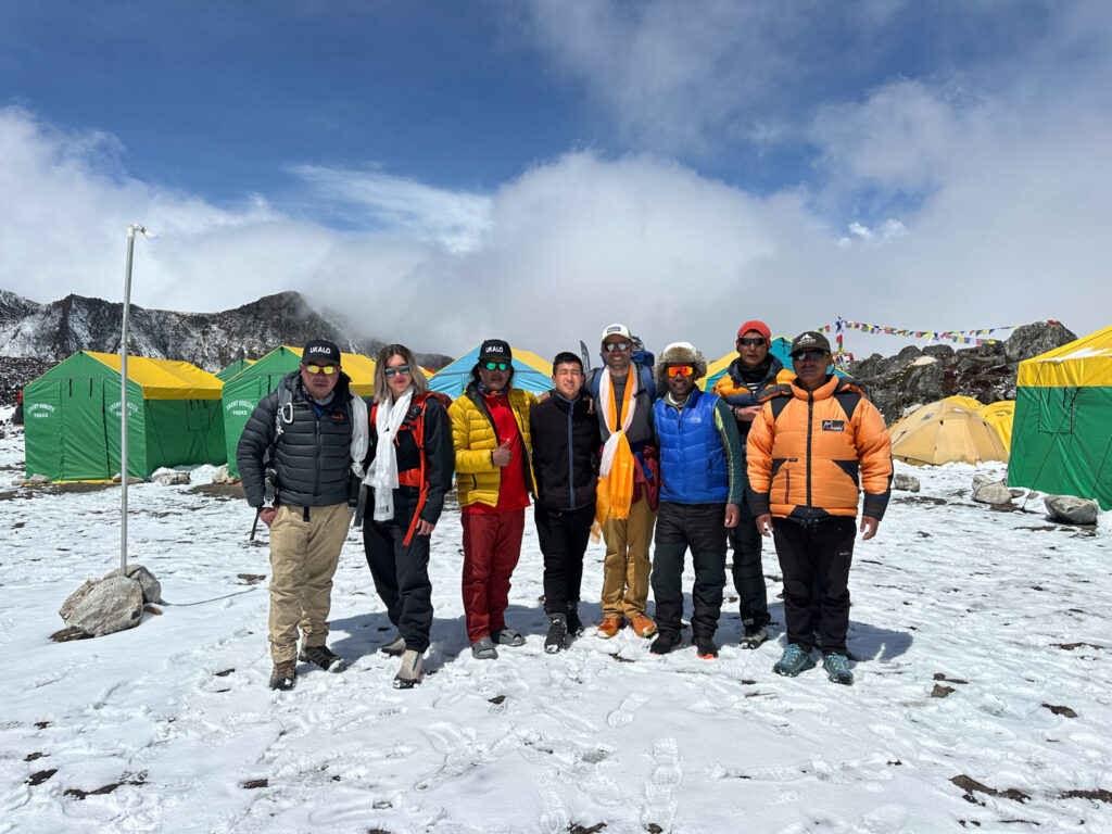 The Life Happens Outdoors team, including Rami Rasamny, posing together at Ama Dablam Base Camp before departing after a challenging climbing season.