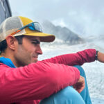 Rami Rasamny sitting on the terrace of the Albert Premiere Hut overlooking the Le Tour Glacier during a Life Happens Outdoors expedition in the Alps.