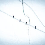 Life Happens Outdoors team members trekking across a vast glacier on the Spaghetti Tour with snow-covered alpine peaks rising in the distance