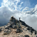 ChatGPT said: LHO climber trekking to Ama Dablam Camp 1 with dramatic clouds and sunlight breaking through, capturing the beauty of this iconic Himalayan climb.