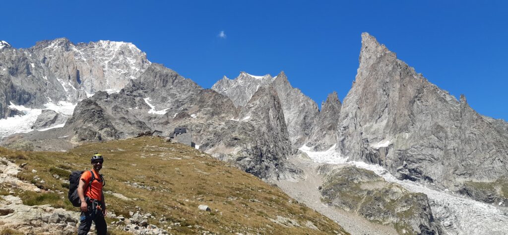 Jean Louis Moukarzel of Life Happens Outdoors standing outside the Monzino Hut during the training stage of his week, surrounded by rugged alpine terrain and towering peaks, preparing for his climb of the Eiger as part of his journey recounted in the article "Am I an Alpinist?