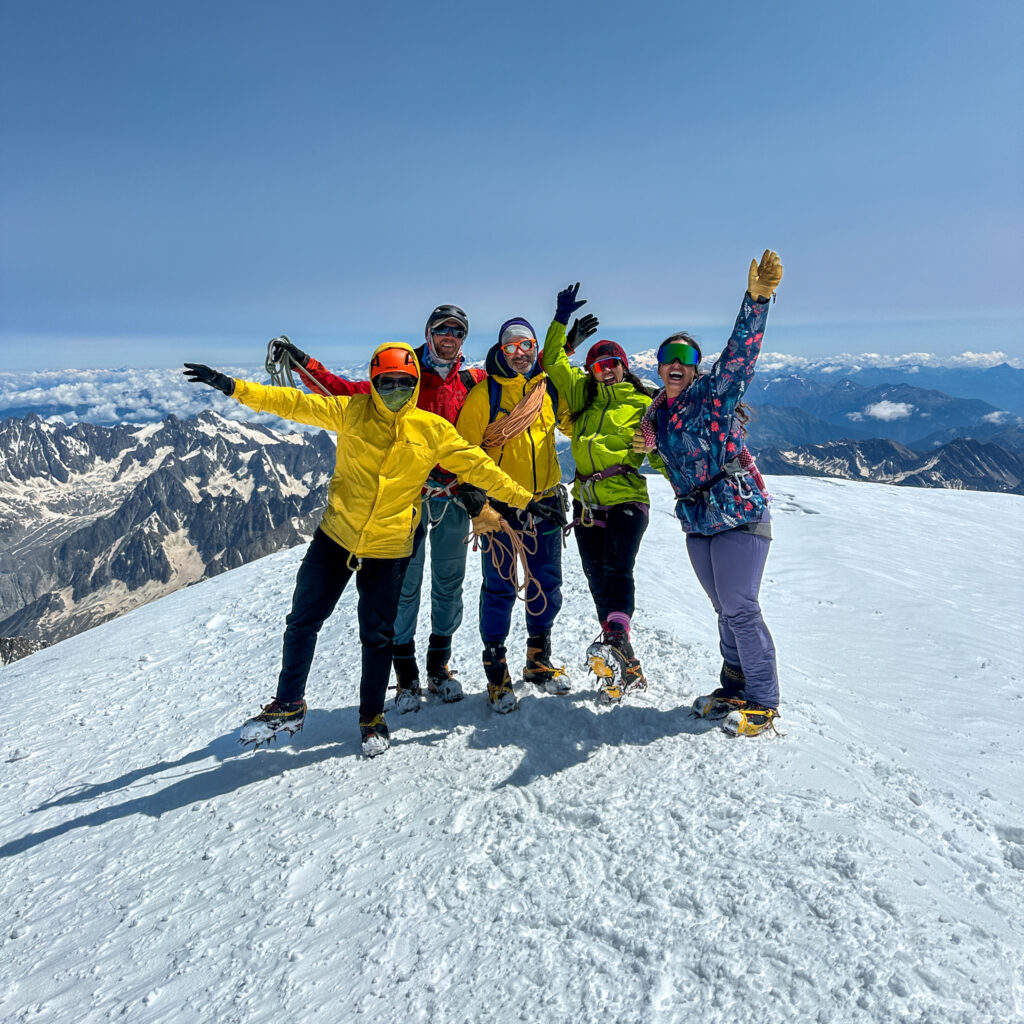 Life Happens Outdoors team on the summit of Mont Blanc in perfect weather during the Mont Blanc Summit Course. Two of the three climbers are first timers who completed the course in the same week they reached the summit, featured in the article Can I Climb Mont Blanc as a Beginner.