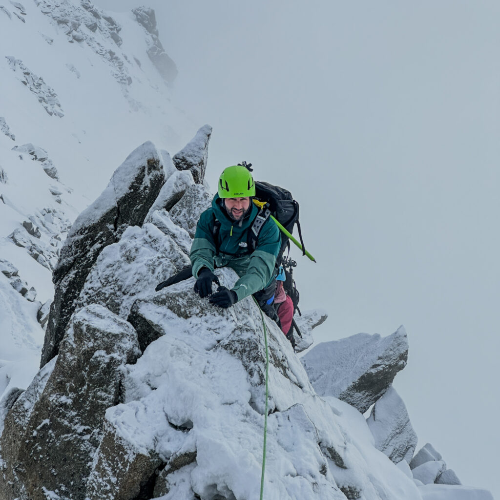 Life Happens Outdoors community member climbing on the Marbrées in snowy and icy conditions during the Mont Blanc Summit Course to train for verglace and rocky ridges, featured in the article Can I Climb Mont Blanc as a Beginner.