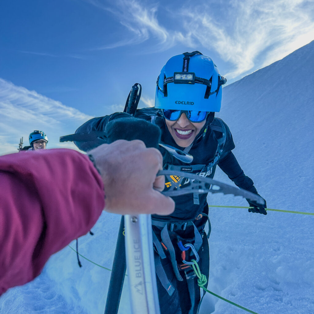 Life Happens Outdoors community member Nada arriving at the Gouter Hut on the Mont Blanc Summit Course, giving expedition photographer and Life Happens Outdoors founder Rami Rasamny a fist pump, featured in the article Can I Climb Mont Blanc as a Beginner.