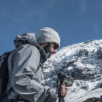 An LHO member trekking toward Barafu Camp with Mount Kilimanjaro rising in the background under clear skies during the summit approach.