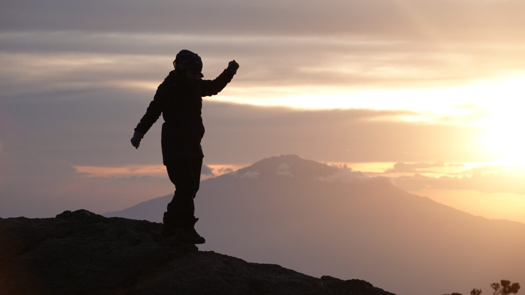 Life Happens Outdoors climber enjoys an epic sunset from Karanga Camp on Mount Kilimanjaro during the ascent toward the summit.