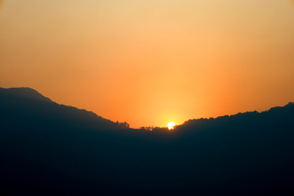 A beautiful sunrise rising behind the Mardi Himal ridge as seen from Chomrong on the Annapurna Base Camp trek, casting golden light over the Himalayas.