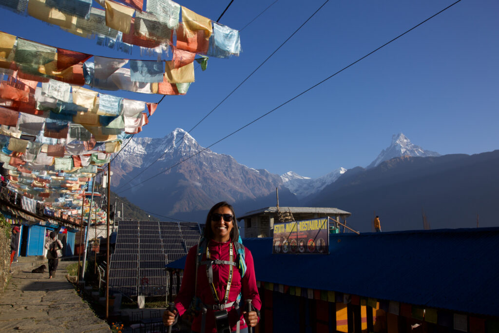 Life Happens Outdoors community member posing in the town of Chumrung with Annapurna South rising in the background in the Annapurna region