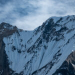 Close-up view of Machapuchare (Fishtail Mountain) against a clear blue sky, photographed from the Annapurna Base Camp trek in beautiful weather.