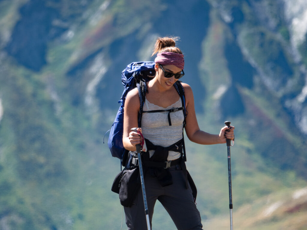 Life Happens Outdoors community member hiking the Tour du Mont Blanc with trekking poles on a high alpine trail above the Chamonix valley.