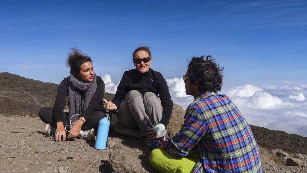 Life Happens Outdoors community members chatting above the clouds on Mount Kilimanjaro during clear weather