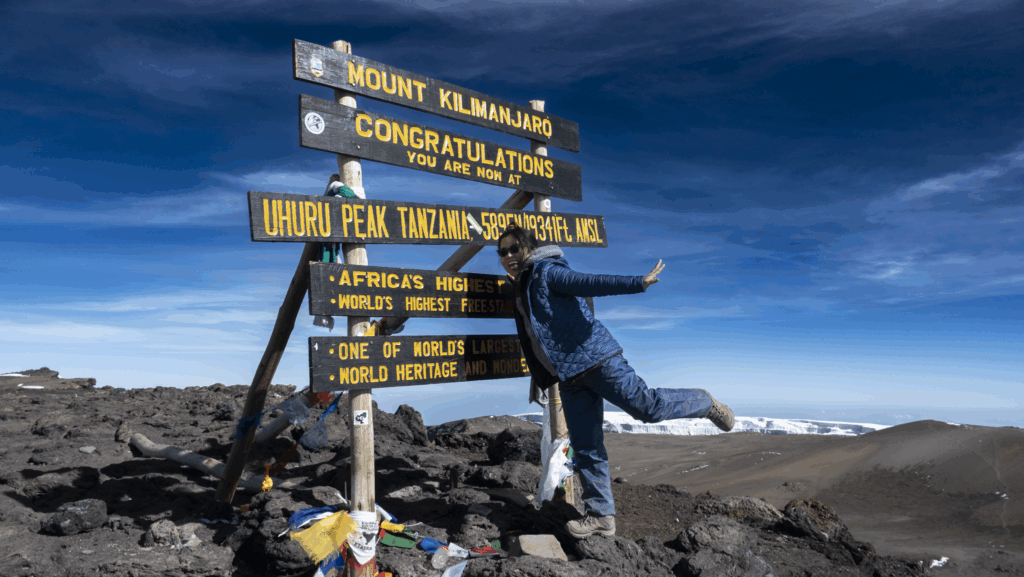 Life Happens Outdoors Community member standing on the summit near the crater rim of Mount Kilimanjaro with glacier views in clear weather