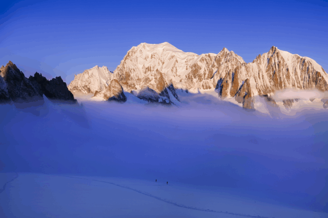 Two Life Happens Outdoors climbers ascending the Vallée Blanche at sunrise with Mont Blanc towering behind them.