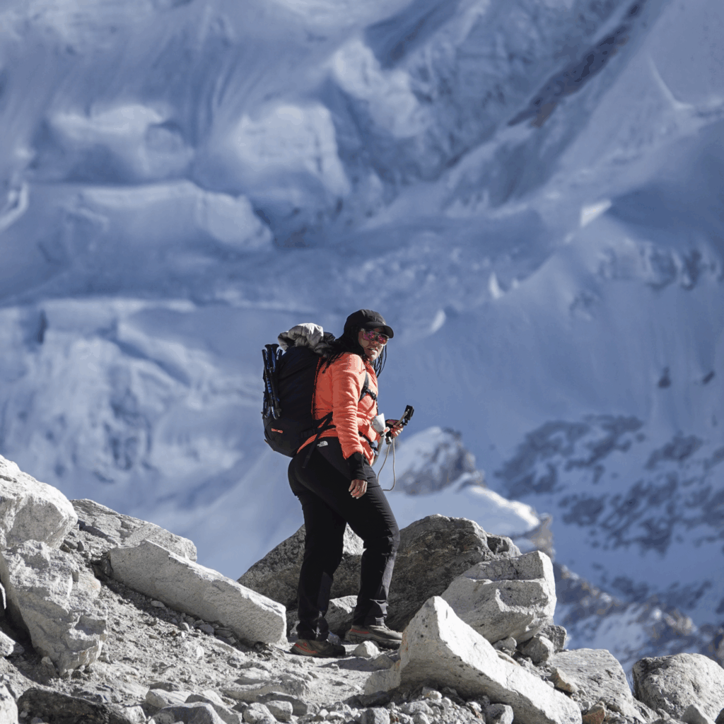 Life Happens Outdoors community member walking along the glacier moraine toward Everest Base Camp with the Khumbu Glacier behind.
