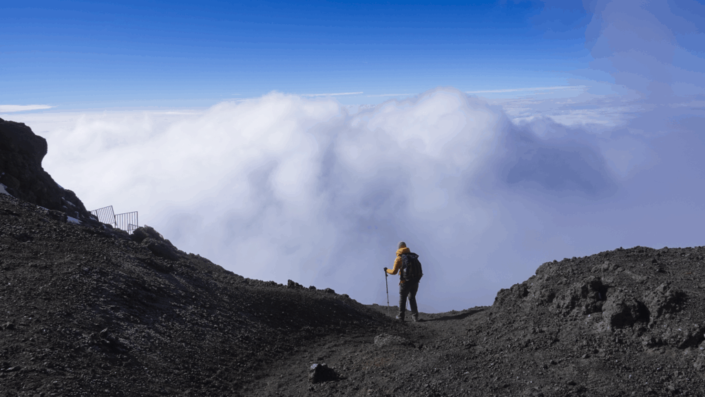 Life Happens Outdoors community member descending from the Kilimanjaro summit above the clouds on the crater rim