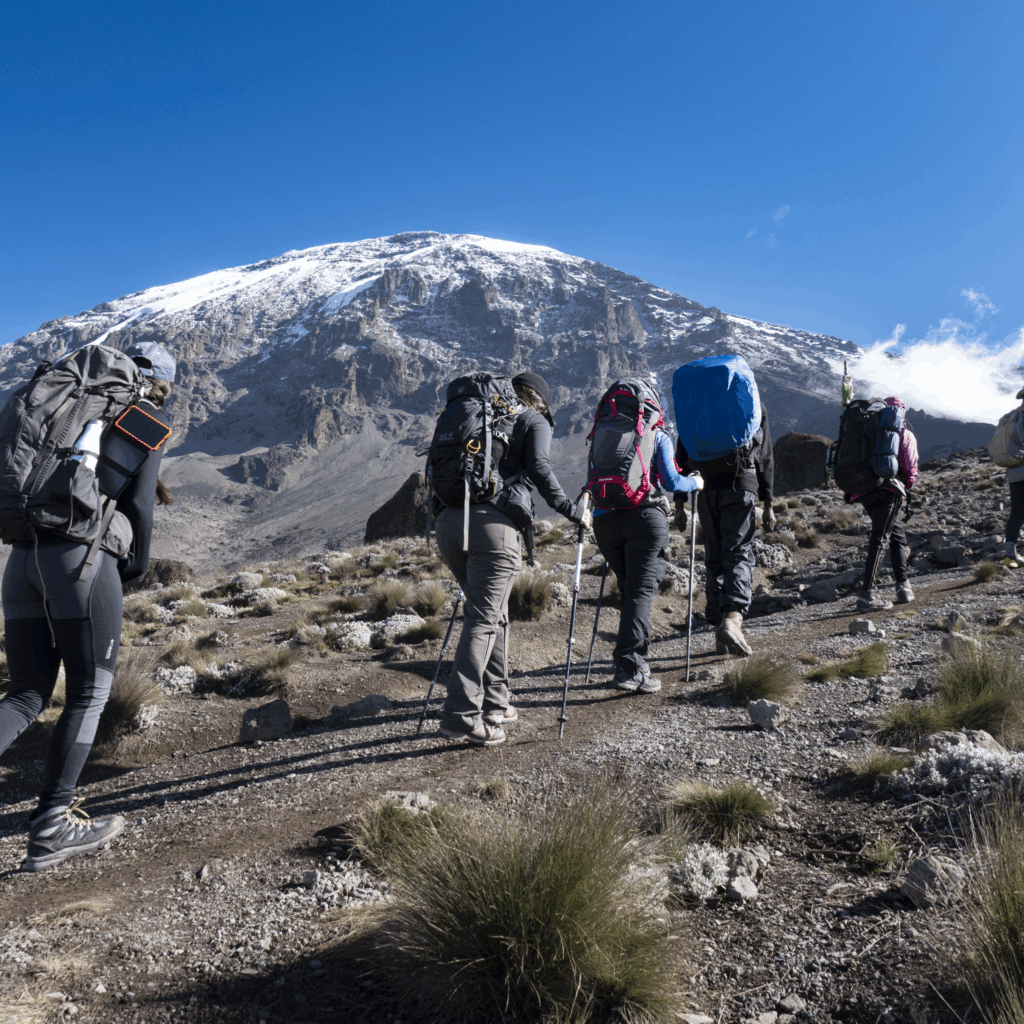 Life Happens Outdoors community members climbing from Karanga to Barafu on the Machame Route on Kilimanjaro, photographed from a different angle with the mountain behind.