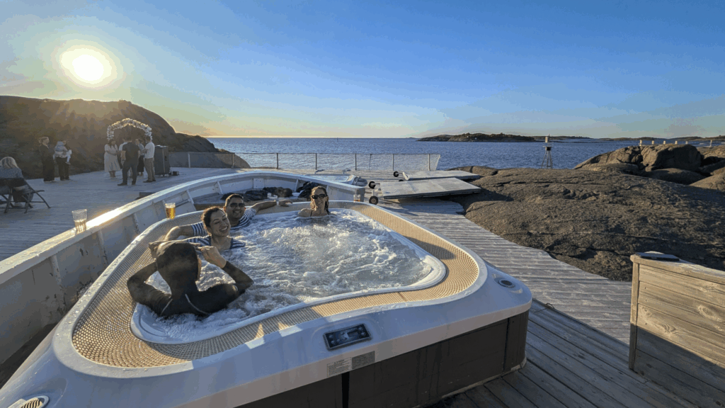 Life Happens Outdoors community members enjoying the midnight sun in a hot tub on Senja during the Explore Arctic Norway trip