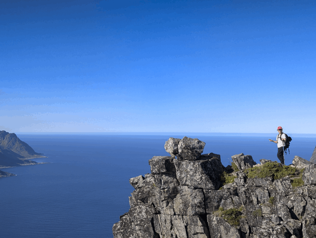 Life Happens Outdoors community member standing on a Senja cliffside overlooking the North Sea during the Explore Arctic Norway trip