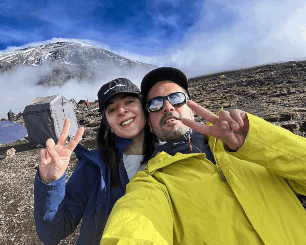 Life Happens Outdoors team leader and community member take a selfie with Mount Kilimanjaro behind them at Karanga Camp on the Machame Route