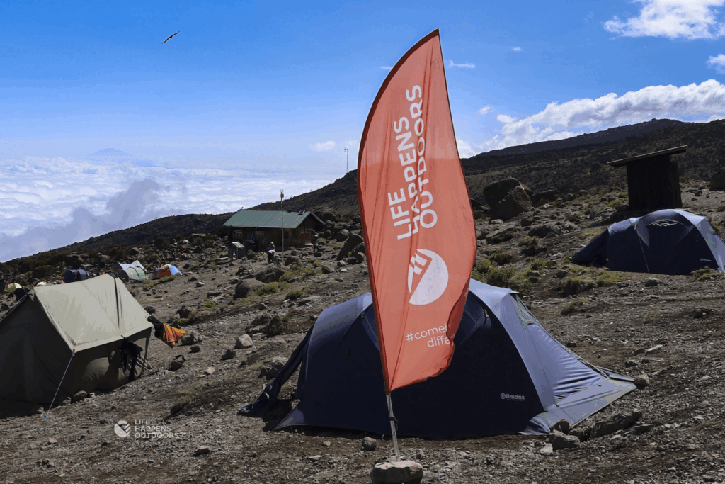 Life Happens Outdoors tent on Kilimanjaro beneath spectacular blue skies during the climbing season