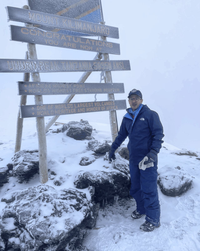 Life Happens Outdoors community member celebrating on the summit of Kilimanjaro after a life changing climb.