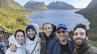 Life Happens Outdoors community members taking a selfie with Norway fjords in the background during a small group adventure.