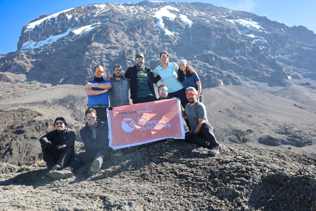 Life Happens Outdoors team on top of the Barranco Wall with Kilimanjaro glaciers above on the Machame Route