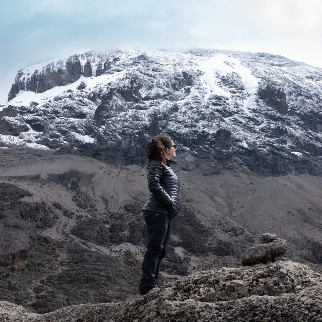 Life Happens Outdoors community member on top of Barranco Wall on the Machame Route looking toward Kilimanjaro summit