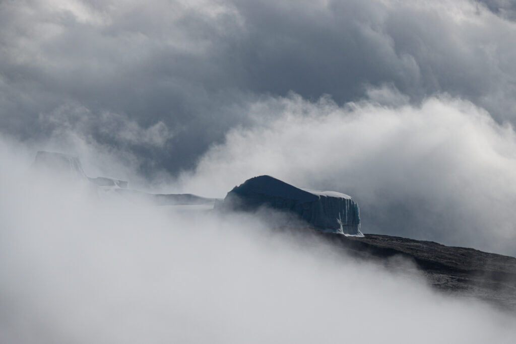 Kilimanjaro glacier emerging through thick cloud on the upper slopes of the mountain.