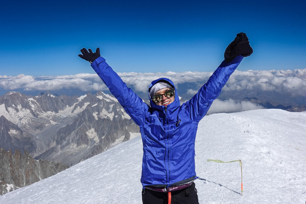 Life Happens Outdoors climber celebrating on a snowy Mont Blanc summit ridge, showing personal growth through mountain adventure