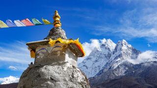 Buddhist stupa and snow covered Himalayan peaks on the Everest Base Camp trekking route in Nepal