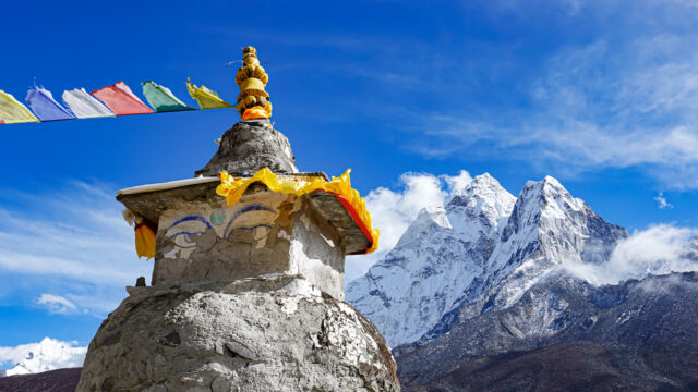 Buddhist stupa and snow covered Himalayan peaks on the Everest Base Camp trekking route in Nepal
